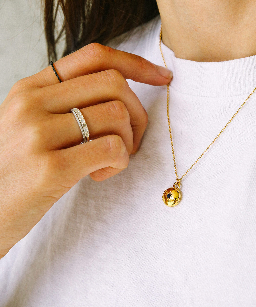Model wearing the Mini Biography Locket Necklace in Yellow Gold Vermeil with Silver rings | The Astley Clarke Blog