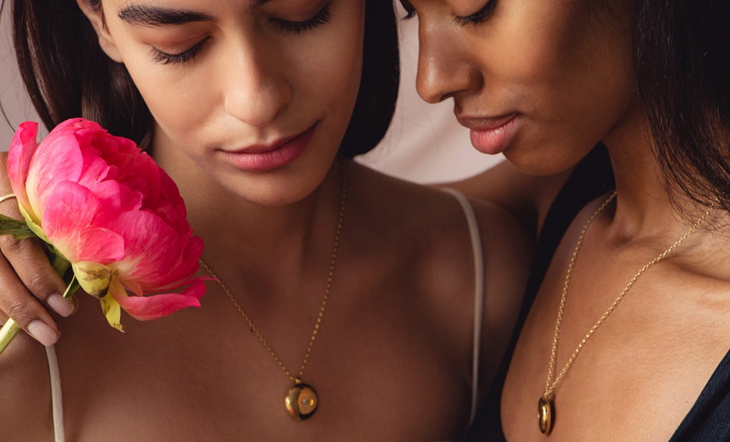 Models wearing Astley Clarke Medium Biography Engravable Photo Locket Necklace in 18ct yellow gold vermeil