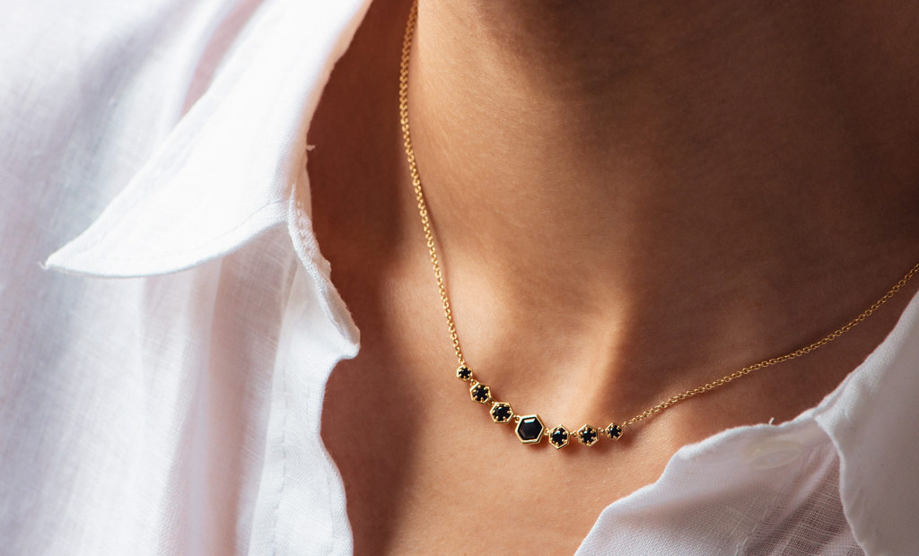 Model wearing Astley Clarke Black Spinel Deco Reversible Detail Necklace in 18ct Gold Plated Sterling Silver