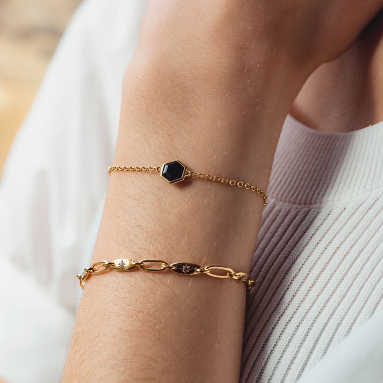 gold bracelet stack with chunky gold chain and black gemstone bracelet