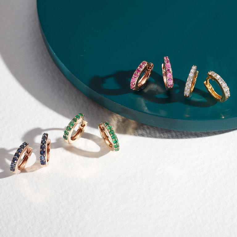 solid gold huggie hoop earrings with blue sapphire huggie hoop earrings, emerald huggie hoop earrings and diamond huggie hoop earrings