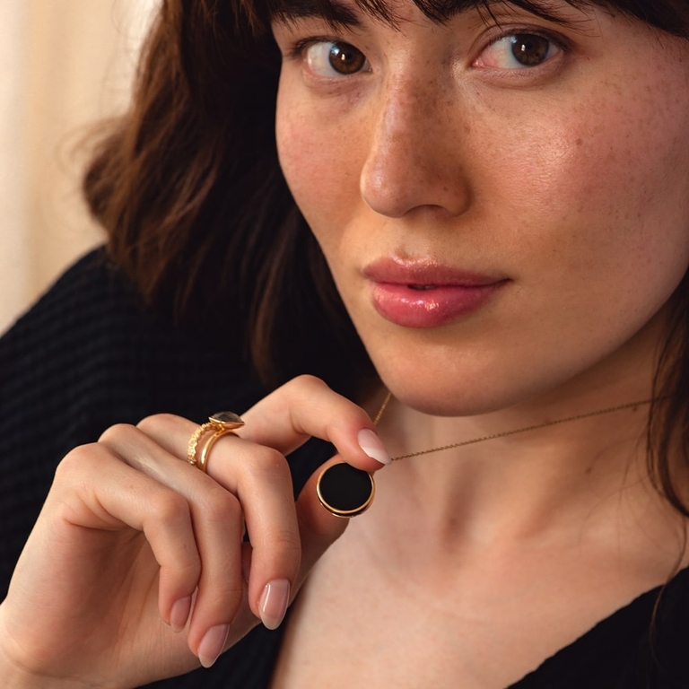 black onyx locket necklace with gold ring stack