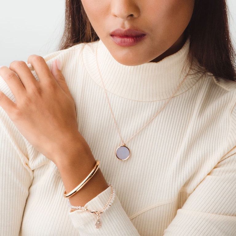 rose gold jewellery stack with rose gold bangle, rose gold moonstone hamsa bracelet and lace agate locket necklace