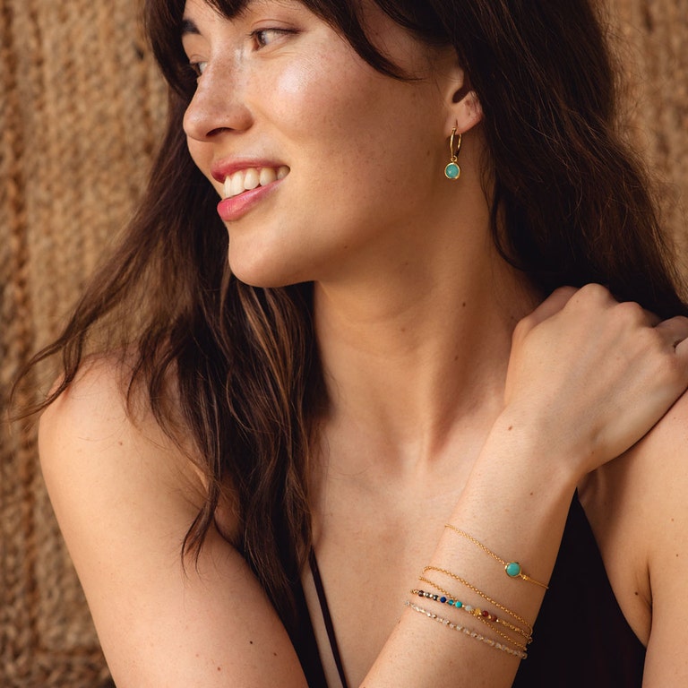 gemstone jewellery collection with amazonite hoop earrings and bracelet stacked with rainbow gemstone bracelet