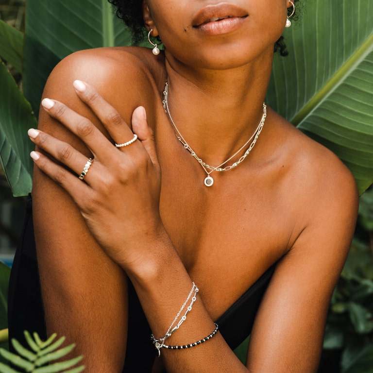 silver jewellery with silver bracelet stack and black gemstone bracelet in silver, silver stacking rings, silver necklaces and silver pearl drop earrings