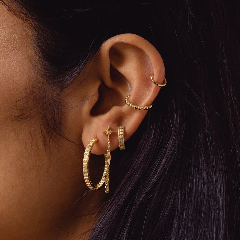 gold earring stack with large gold hoop earring, gold chain earring, gold huggie hoop earring, gold ear cuff and 14ct solid yellow gold cartilage hoop earring