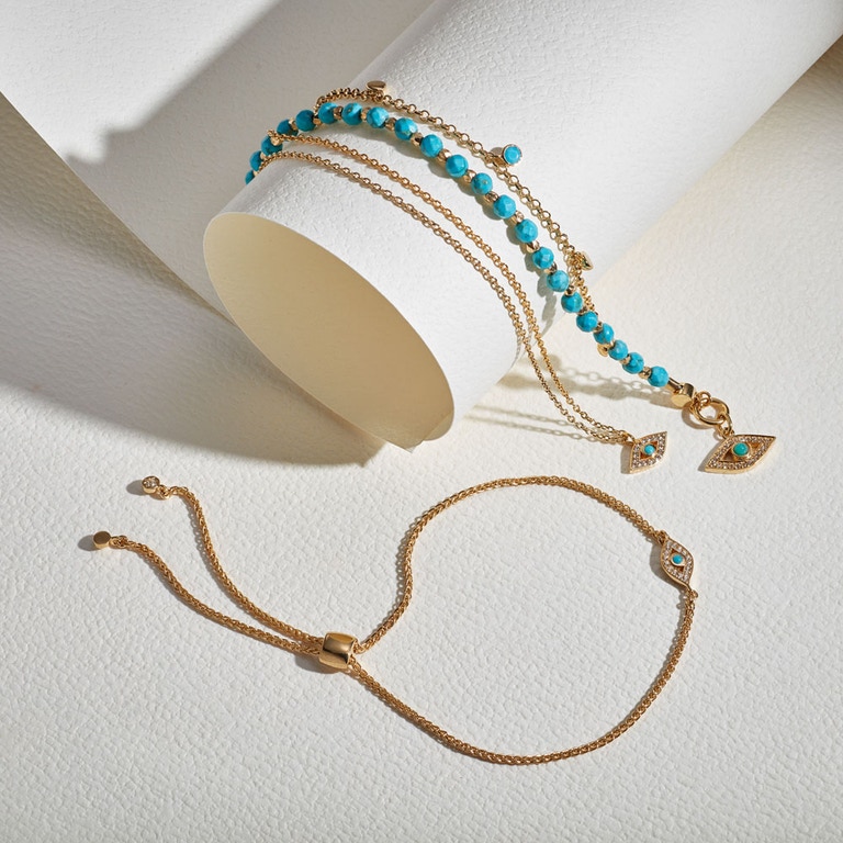 still life image of evil eye jewellery with evil eye kula bracelet, gold evil eye pendant and turquoise evil eye bracelet