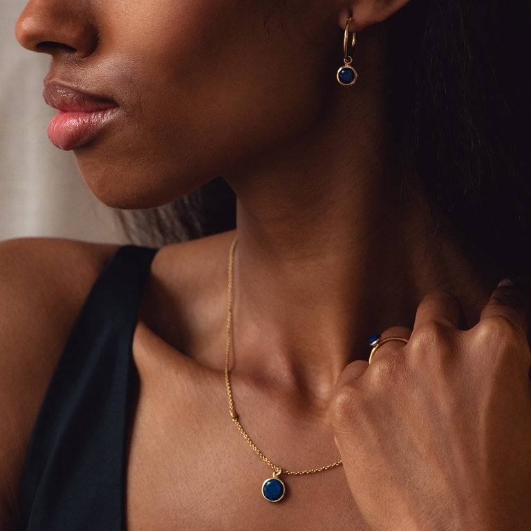 gold pendant necklace with lapis lazuli and gold hoop earring with lapis lazuli drop