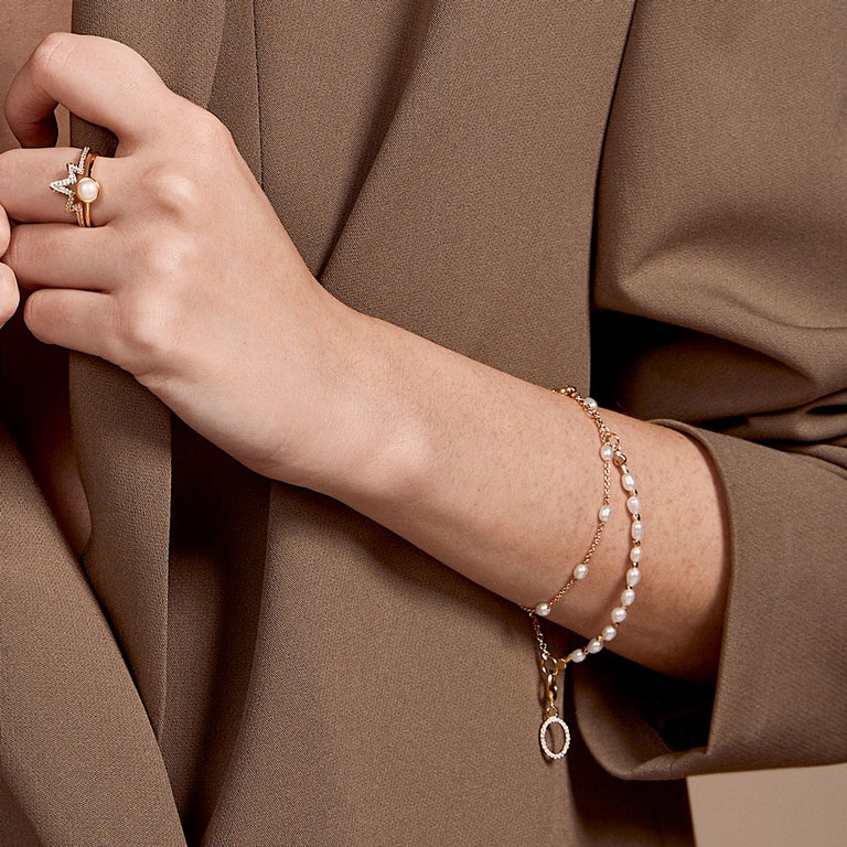 gold pear jewellery stack with pearl stacking ring and gold pearl charm bracelet