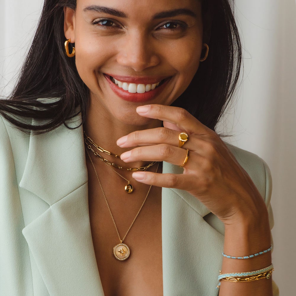 gold jewellery stack with some blue fabric pieces