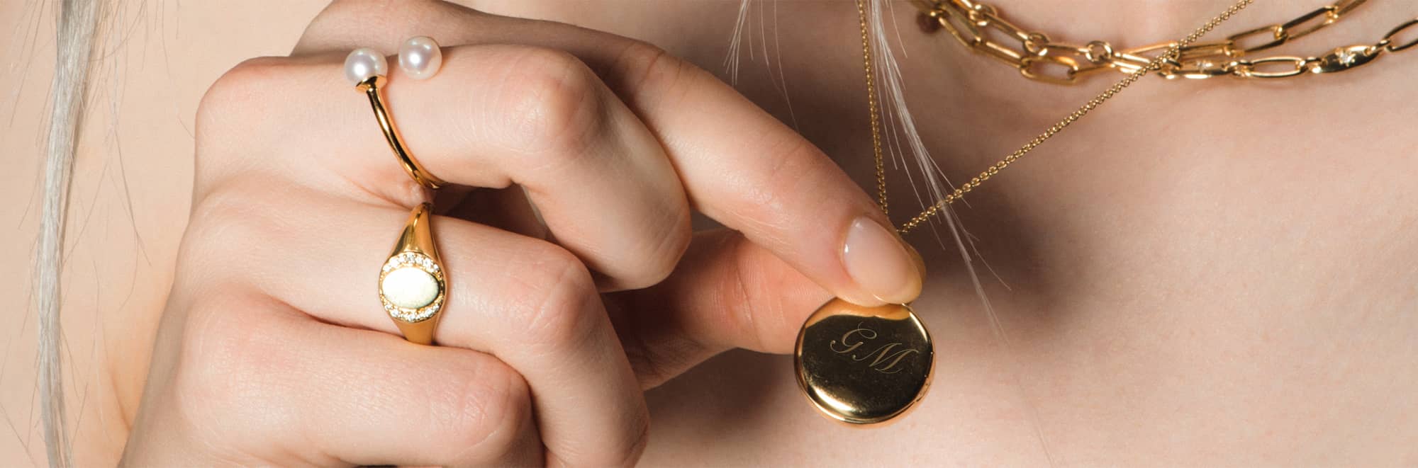 Gold jewellery stack with engraved locket